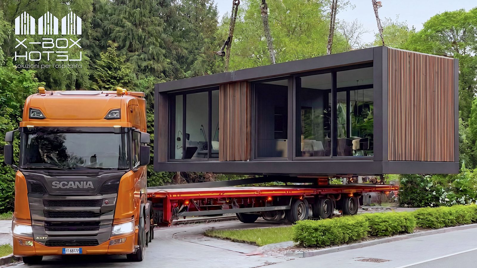 Modulo X-BOX HOTEL finito, sollevato dalla gru durante lo scarico dal trasporto eccezionale